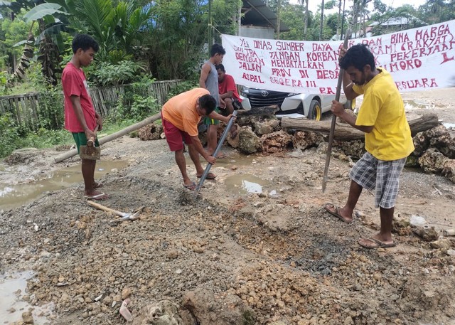 Sejumlah warga sedang menggali jalan dan memblokirnya menggunakan batu sebagai buntut kekesalan mereka kareja jalan rusak tak kunjung diperbaiki. Foto: Jum/Istimewa.