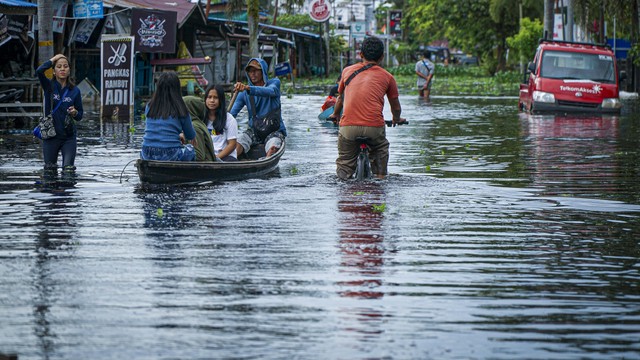 Warga berusaha menerobos jalan yang terendam banjir di Tanjung Puri, Kabupaten Sintang, Kalimantan Barat. Foto: ANTARA FOTO/Abraham Mudito