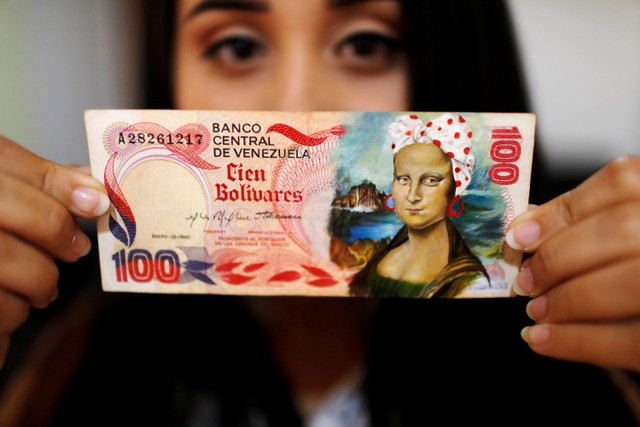 Elianni Di Gregorio menunjukkan uang kertas bolivar lama sebagai kanvas untuk lukisannya di Valencia, Venezuela. Foto: Leonardo Fernandez Viloria/REUTERS
