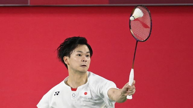 Yuta Watanabe dari Jepang melakukan pukulan dalam sebuah pertandingan penyisihan grup bulu tangkis ganda putra. Foto: Alexander N / AFP