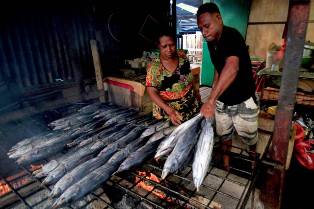 Pedagang mengolah ikan asar (ikan cakalang asap) di Pasar Sentral Hamadi, Jayapura, Papua, Senin (15/11/2021). Foto: Gusti Tanati/Antara Foto