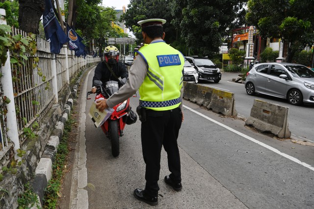 Petugas kepolisian memberhentikan kendaraan yang memasuki jalur khusus Transjakarta saat Operasi Zebra Jaya 2021 di Jalan Arteri Pondok Indah, Jakarta Foto: ANTARA FOTO/Hafidz Mubarak A