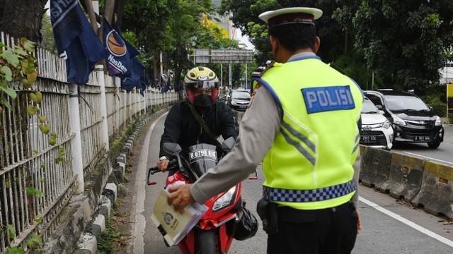 Petugas kepolisian memberhentikan kendaraan yang memasuki jalur khusus Transjakarta saat Operasi Zebra Jaya 2021 di Jalan Arteri Pondok Indah, Jakarta. Foto: ANTARA FOTO/Hafidz Mubarak A