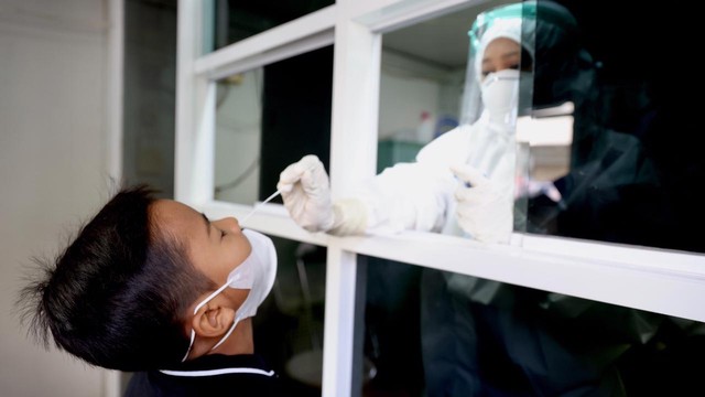 Seorang anak menjalani pemeriksaan swab COVID-19. Foto: Suparta/acehkini