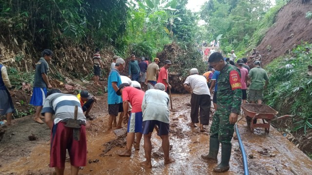 Warga bersama Babinsa bergotong roypngbmembersihkan longsoranbyang tutupi jalan. Foto: istimewa.