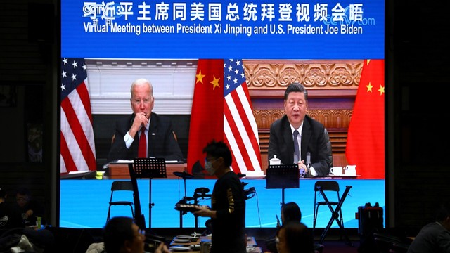 Layar yang menampilkan pertemuan virtual Presiden Amerika Serikat Joe Biden dengan Presiden China Xi Jinping di sebuah restoran di Beijing, China. Foto: Tingshu Wang/REUTERS