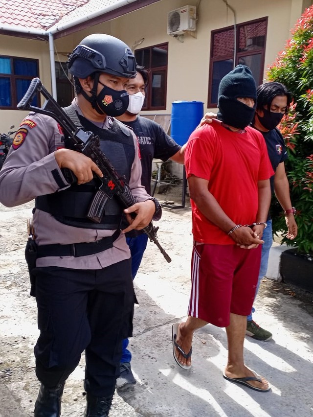 Pelaku pembunuhan guru SMK di Aceh Barat dikawal polisi untuk dihadirkan pada konferensi pers di Mapolres Aceh Barat, Selasa (16/11). Foto: Siti Aisyah/acehkini  