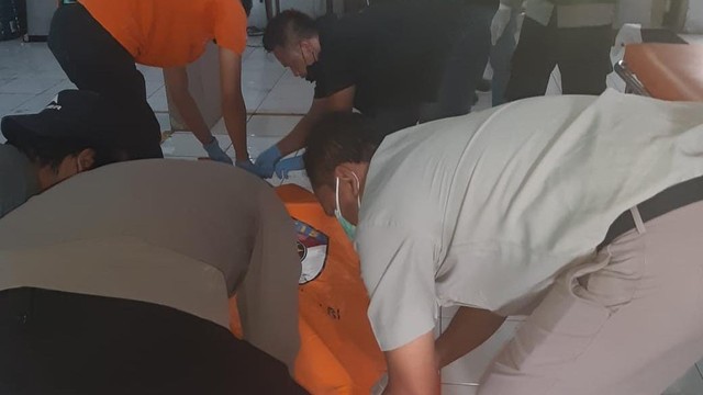 Polisi mengevakuasi mayat satpam yang terbunuh dalam peristiwa perampokan gudang rokok Camel di Solo, Senin (15/11/2021)