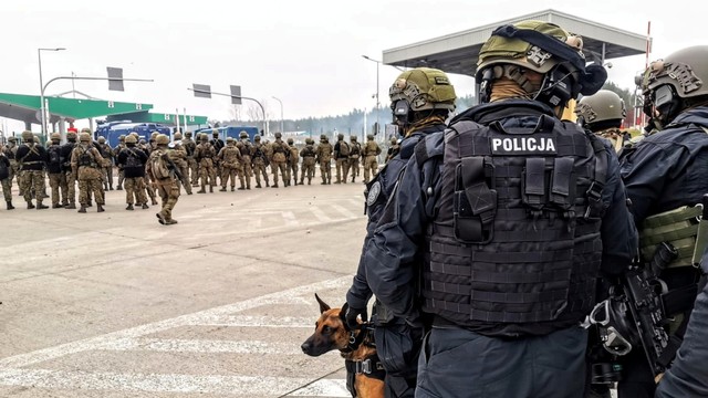 Polisi Polandia berjaga di pos pemeriksaan Kuznica - Bruzgi saat imigran berpaya menyeberangi perbatasan ke Polandia. Foto: Policja Podlaska/Handout via REUTERS