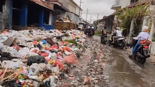 Sampah menumpuk penuhi jalan hingga bikin macet. (Foto: @wecarebangkalanmadura/Instagram)
