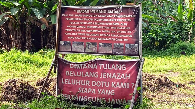 Spanduk yang dibentangkan oleh ahli waris keluarga Baginda, yang mempertanyakan pembongkaran makam nenek moyang mereka di lahan pembangunan jalan Boulevard II di Kecamatan Bunaken, Kota Manado 