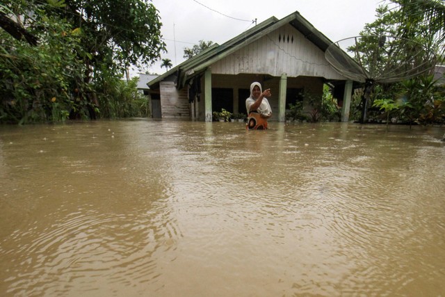 Warga bertahan di rumahnya yang terkepung banjir di Desa Hagu, Kecamatan Matang Kuli, Aceh Utara, Aceh, Rabu (17/11/2021). Foto: Rahmad/Antara Foto