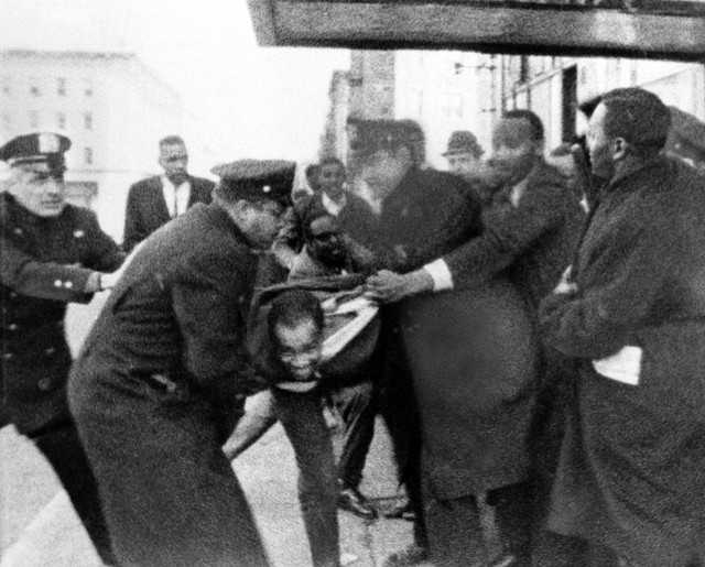 Foto ini, dirilis oleh WCBS-TV, menunjukkan Thomas Hagan, 22, berjuang dengan polisi yang membawanya dari tempat kejadian di luar ballroom tempat Malcolm X ditembak dan dibunuh di New York, 21 Februari 1965. Foto: AP Photo