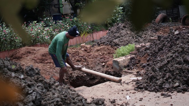 Pekerja menyelesaikan proyek galian sumur resapan di kawasan Duren Sawit, Jakarta Timur, Selasa (18/11/2021). Foto: Jamal Ramadhan/kumparan