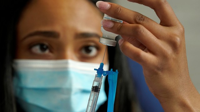 Perawat memasukkan vaksin Moderna COVID-19 ke dalam jarum suntik di klinik vaksinasi massal di Gillette Stadium, di Foxborough, Mass, AS. Foto: Steven Senne/AP Photo