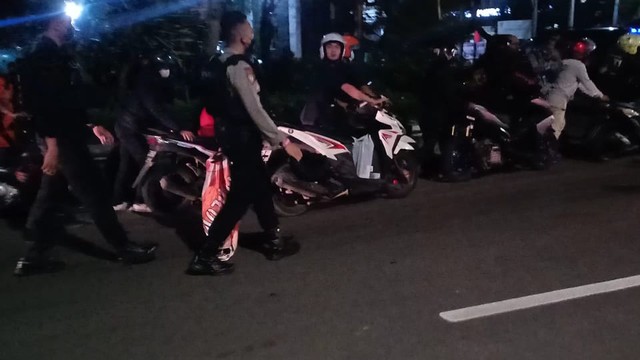 Polisi Solo mengadang konvoi motor sekelompok orang beratribut suporter Jakmania. FOTO: Agung Santoso