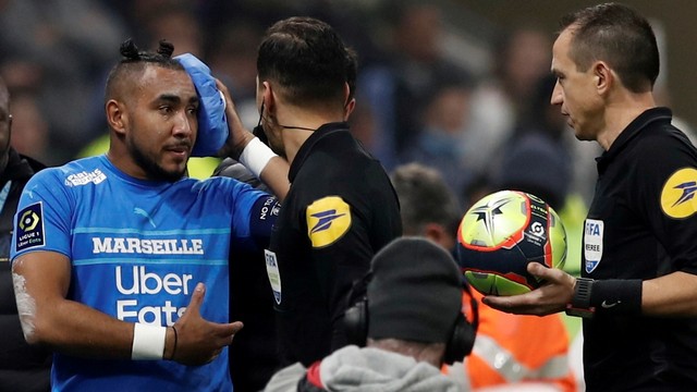 Pemain Olympique de Marseille Dimitri Payet berjalan keluar lapangan karena cedera setelah terkena botol air yang dilemparkan oleh seorang penggemar, di Stadion Groupama, Lyon, Prancis, Minggu (21/11). Foto: Benoit Tessier/REUTERS