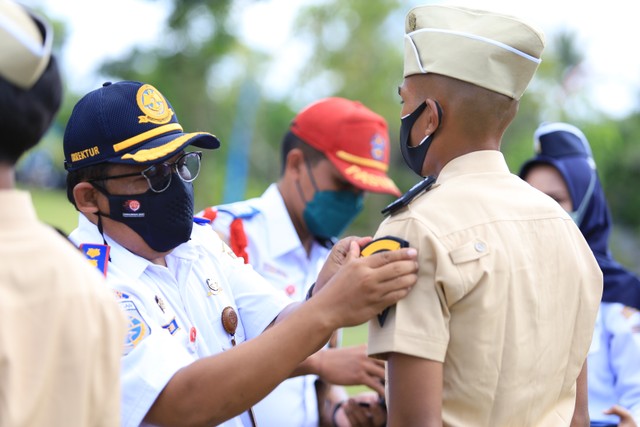 Direktur Poltrada Bali, Dr. Efendhi Prih Raharjo menyematkan simbol taruna Poltrada Bali- IST