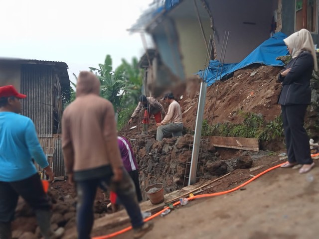 Anggota Fraksi Gerindra Bintang DPRD Kuningan, Sri Laelasari saat meninjau rumah warga terdampak longsor di Kuningan, Jawa Barat. (Andri)