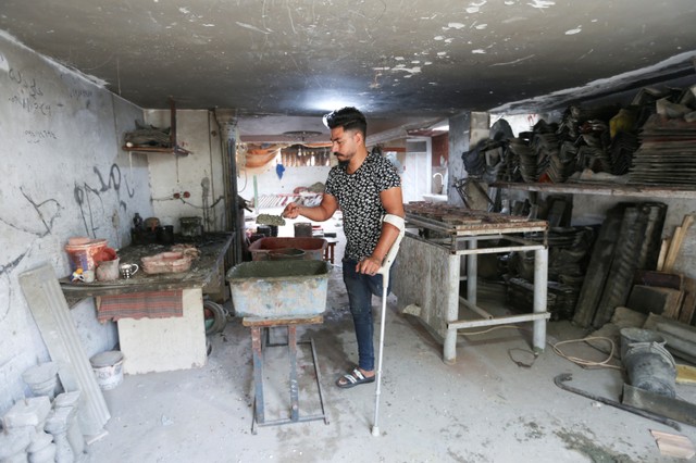 Pria Palestina Hussam Jarboa bekerja di bengkel ubinnya, di Rafah di Jalur Gaza selatan. Foto: Ibraheem Abu Mustofa/REUTERS
