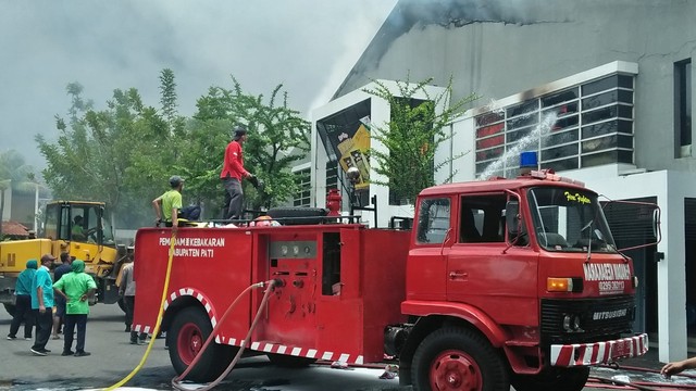 Petugas pemadam kebakaran saat memadamkan api yang membakar pabrik kacang dua kelinci Pati, Jawa Tengah, Selasa (23/11). Foto: Polsek Margorejo