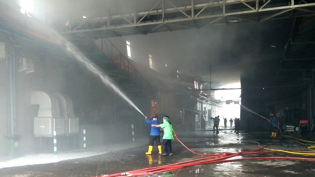 Petugas pemadam kebakaran saat memadamkan api yang membakar pabrik kacang dua kelinci Pati, Jawa Tengah, Selasa (23/11). Foto: Polsek Margorejo
