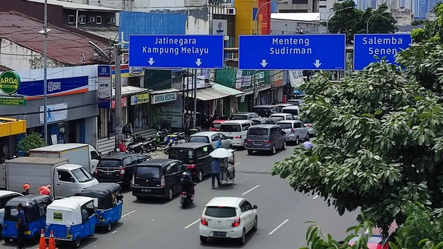 Kendaraan parkir hingga 1/4 lebar jalan raya di dekat Pasar Jaya Pramuka, Jakarta, Selasa (23/11/2021). Foto: Jamal Ramadhan/kumparan