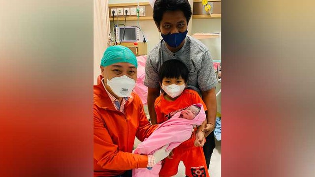 Dokter spesialis obgyn Morula IVF Surabaya dr. Benediktus Arifin, MPH, SpOG(K), FICS, saat menggendong bayi Khadijah Adzkiya. Bayi Khadijah terlahir dari embrio yang disimpan sejak 6 tahun lalu. Foto: Istimewa