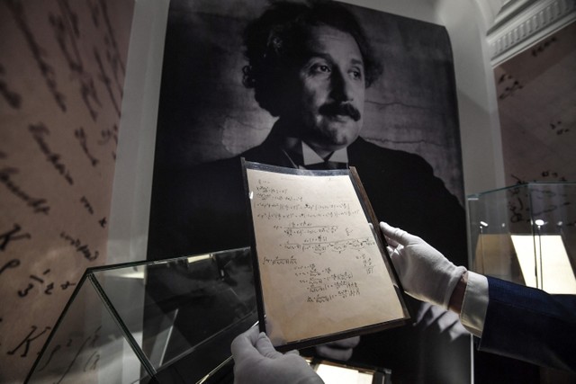 Sebuah halaman manuskrip Einstein, salah satu naskah persiapan teori relativitas dipajang di rumah lelang Christie's di Paris, Prancis. Foto: Alain JOCARD / AFP