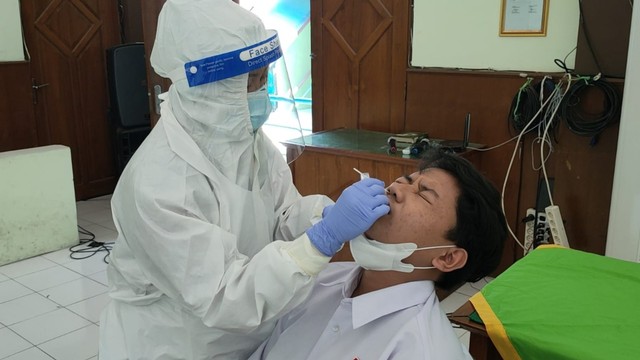 Petugas kesehatan melakukan tes swab di Madrasah Aliyyah Negeri I Solo, Kamis (25/11/2021). FOTO: Agung Santoso