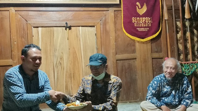 Wasekjen Senapati Nusantara, Nurjianto, memberikan potongan nasi tumpeng pada tetua keris Yogyakarta, Amy Adam Prsitojati pada Rabu (24/11) di Sanggar Keris Mataram, Bantul, DIY. Foto: ESP