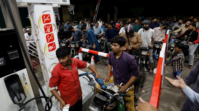 Orang-orang yang mengendarai sepeda motor menunggu giliran untuk mengantre di sebuah pompa bensin, di Karachi, Pakistan, Rabu (24/11). Foto: Akhtar Soomro/REUTERS