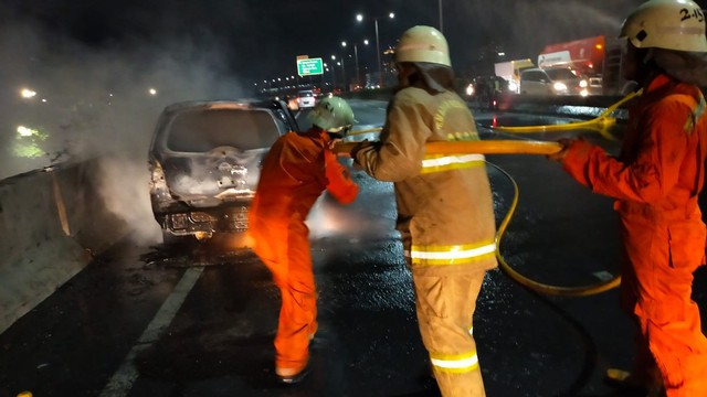 Proses pemadaman mobil yang terbakar di Jal Tol Wiyoto Wiyono, Jakarta Utara. Foto: Dok. Istimewa