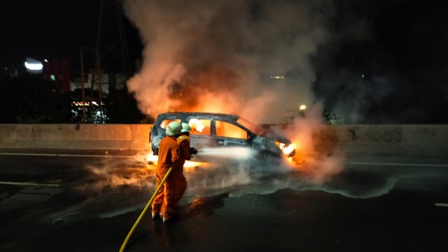 Proses pemadaman mobil yang terbakar di Jal Tol Wiyoto Wiyono , Jakarta Utara. Foto: Dok. Istimewa