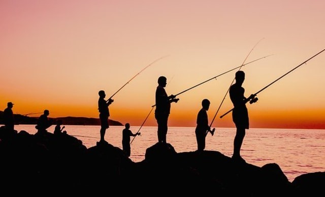 Ilustrasi sekelompok orang sedang memancing di tepi laut. Foto: Pixabay