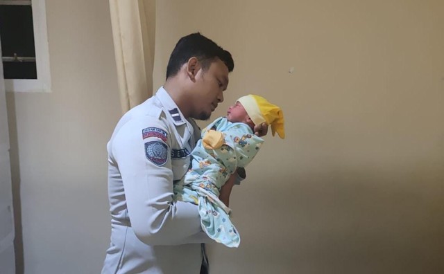 Petugas Rutan Gresik Agung Setyo Darminto mengumandangakn azan dan iqomah kepada bayi yang baru dilahirkan seorang warga binaan pemasyarakatan.