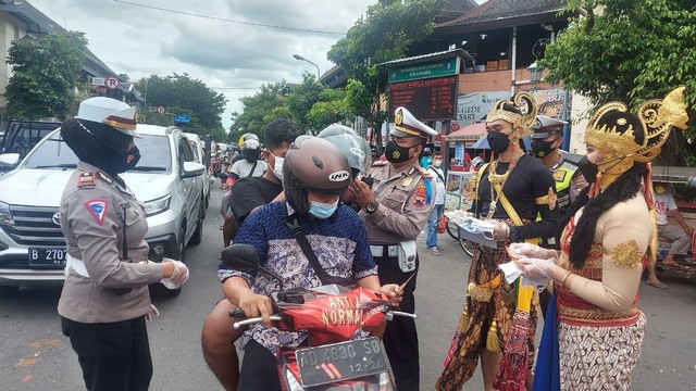 Polisi Solo mengajak tokoh wayang Arjuna dan Srikandi untuk membagikan masker di Operasi Zebra. FOTO: Agung Santoso