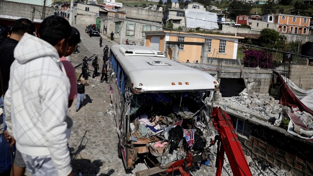 Personel pemerintah bekerja di lokasi bus penumpang yang menabrak sebuah rumah, di San Jose El Guarda, Meksiko, Jumat (26/11). Foto: Luis Cortes/REUTERS