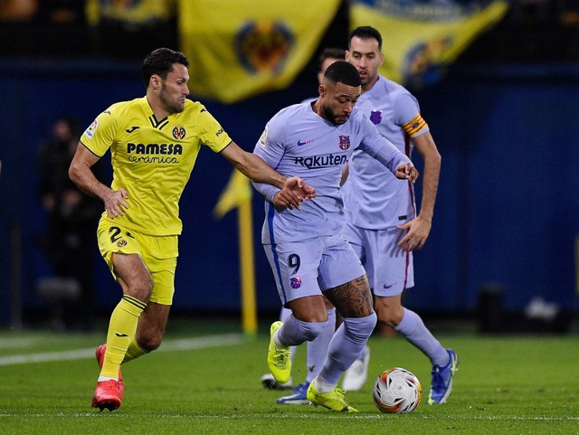 Alfonso Pedraza dari Villarreal beraksi dengan Memphis Depay dari FC Barcelona pada pertandingan LaLiga antara Villarreal melawan FC Barcelona di Estadio de la Ceramica, Villarreal, Spanyol - 27 November 2021. Foto: Pablo Morano/REUTERS