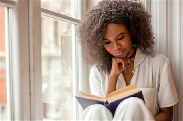 Gambar seorang wanita membaca buku. (Sumber: https://www.shutterstock.com/id/image-photo/pretty-afroamerican-girl-reading-book-sitting-682208722)