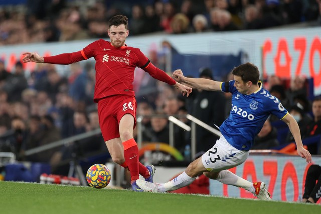 Pemain Liverpool Andrew Robertson berebut bola dengan pemain Everton Seamus Coleman pada pertandingan lanjutan Liga Inggris di Goodison Park, Liverpool, Inggris. Foto: Carl Recine/REUTERS