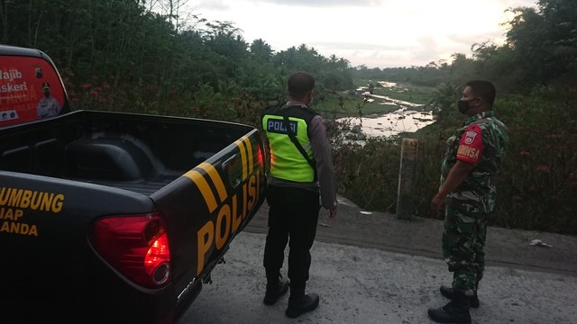 Polisi yang mencari keberadaan sopir truk yang terseret banjir di Lereng Merapi. Foto: istimewa. 