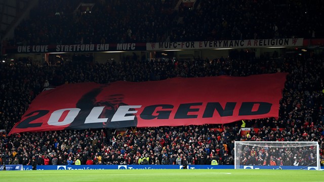 Fans Manchester United mengibarkan bendera untuk mendukung Mantan Pemain dan Manajer, Ole Gunnar Solskjaer, di Stadion Old Trafford, Manchester, Inggris, Kamis (2/12). Foto: Shaun Botterill/Getty Images