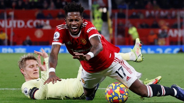 Pemain Arsenal Martin Odegaard melanggar pemain Manchester United Fred di Stadion Old Trafford, Manchester, Inggris, Kamis (2/12). Foto: Phil Noble/REUTERS