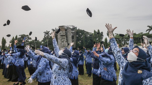 Sejumlah Pegawai Negeri Sipil (PNS) melempar peci usai upacara pelantikan Foto: ANTARA FOTO/Yulius Satria Wijaya