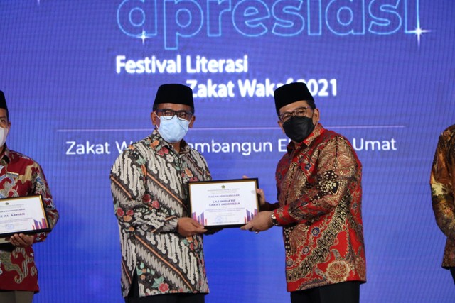 Drs. H. Zainut Tauhid Sa'adi, M.Si menyerahkan piagam penghargaan kepada Wildhan Dewayana selaku Direktur Utama Inisiatif Zakat Indonesia (IZI)