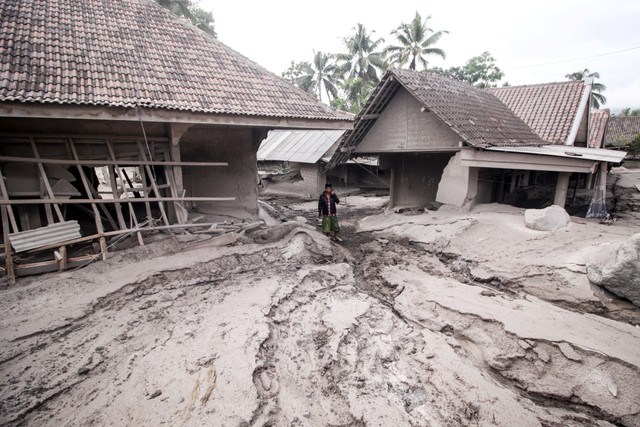 Warga melintas di rumah yang rusak akibat abu vulkanik letusan Gunung Semeru di Desa Sumber Wuluh, Lumajang, Jawa Timur, Minggu (5/12/2021).
 Foto: Umarul Faruq/Antara Foto