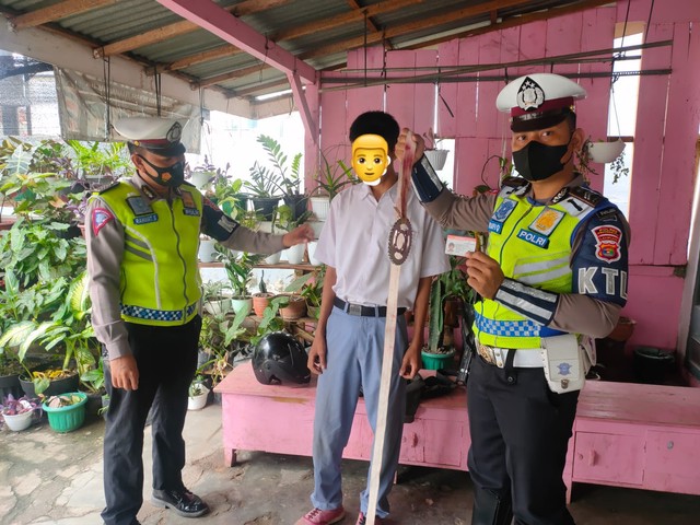 Polisi lalu lintas amankan pelajar SMK di Pringsewu Lampung yang bawa gir dililit kain saat berangkat sekolah, Senin (6/12). | Foto: Polres Pringsewu