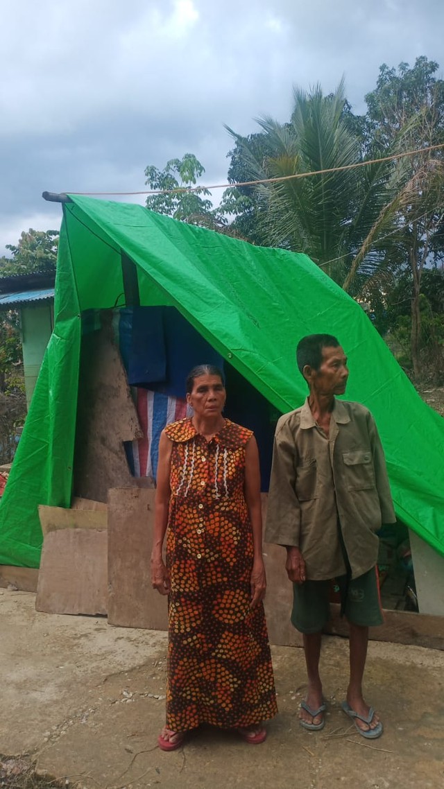Pasangan lansia Bujang dan Ratna di depan tempat tinggal sederhana pasca-rumahnya roboh akibat banjir. Foto: Dok. Istimewa