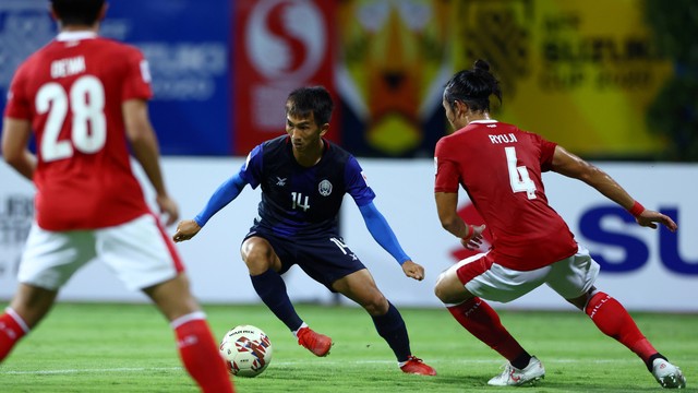 Pemain Timnas Kamboja Keo Sokpheng beraksi dengan Pemain Timnas Indonesia Ryuji Utomo Prabowo pada pertandingan Grup B AFF Suzuki Cup di Stadion Bishan, Singapura, Kamis (9/12). Foto: Yong Teck Lim/Getty Images